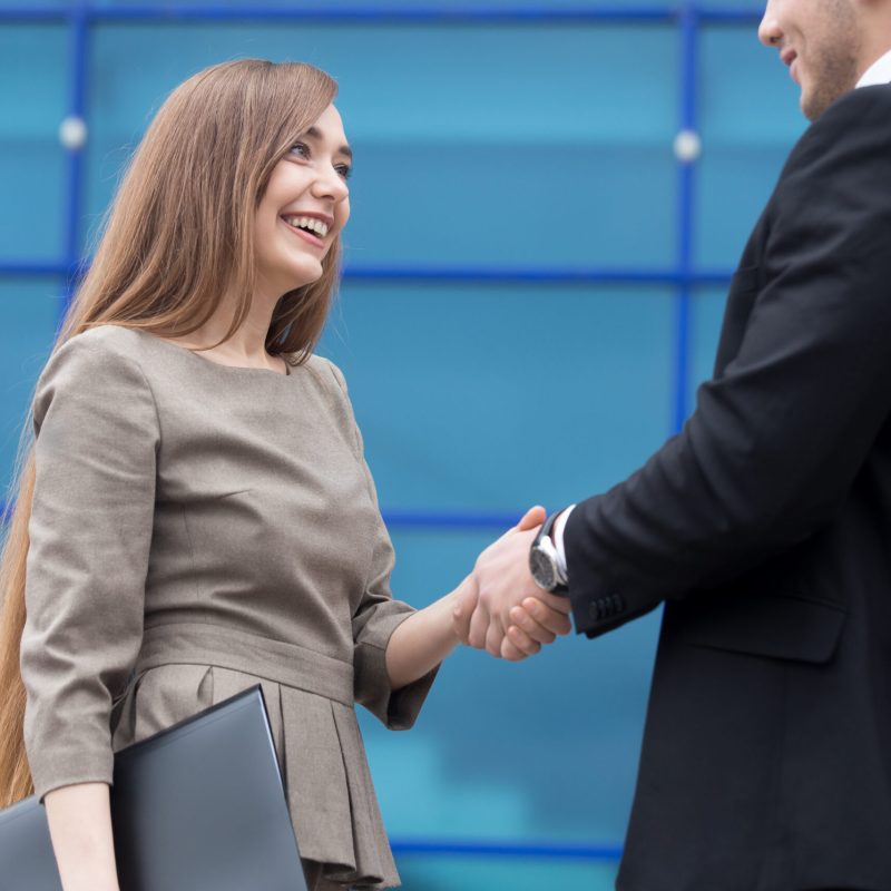 Successful business people shaking hands for greeting or in agreement happy to work together. Focus on smiling businesswoman. Successful Deal Concept. Businesspeople Teamwork